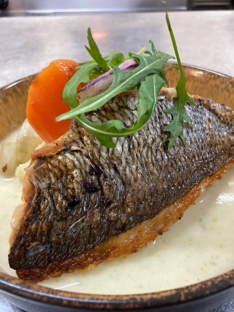 Plat de poisson avec sauce dans un restaurant à Plancoët